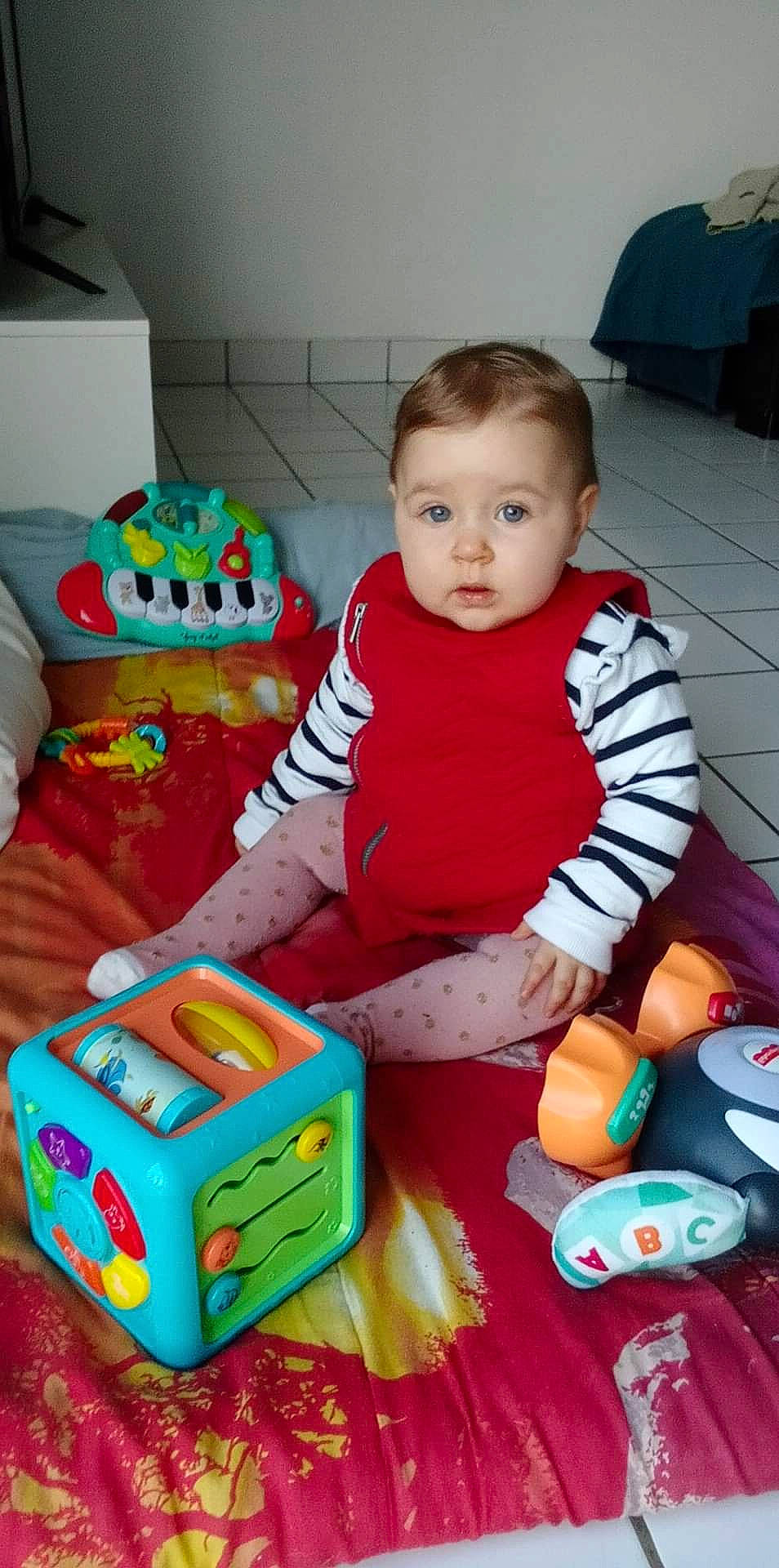 Louna a rejoint le concours — aidez-le/la à gagner de superbes lots ! baby, baby_playing_with_toys, baby_products, baby_toddler_clothing, baby_toys, child, event, flooring, fun, person, plastic, play, product, red, room, sitting, skin, toddler, toy, toy_vehicle