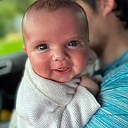 Everleigh-Rose is registered to the contest to win money with this photo: baby, child, smiling, closeup, person, face, sweater, blue_shirt, holding, portrait, happy, cute, infant, human, indoors, blurred_background, skin, eyes, head, family