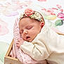 Victoire participe au concours pour gagner de l'argent avec cette photo : baby, sleeping, headband, flower, knitted_blanket, wooden_box, cream_sweater, peaceful, portrait, infant, cute, soft_texture, pink, white, closeup, cozy, indoors, newborn, resting, decorative_background