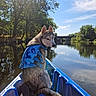 Bunnie a rejoint le concours — aidez-le/la à gagner de superbes lots ! dog, husky, life_jacket, kayak, river, water, trees, bridge, sky, clouds, reflection, sunlight, person, footwear, outdoor, nature, animal, pet, adventure, calm