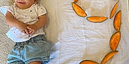 Roukaya a rejoint le concours — aidez-le/la à gagner de superbes lots ! baby, child, cantaloupe, fruit, number, carpet, cloth, smiling, infant, casual_clothing, shorts, tshirt, laying_down, indoor, healthy_food, orange, fresh, cute, relaxed, playful