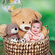 Roukaya participe au concours pour gagner de l'argent avec cette photo : baby, teddy_bear, basket, plush_toy, headband, smile, child, green_background, wooden_floor, cute, indoor, portrait, cozy, toy, infant, happy, sitting, decor, warm_light, photo_shoot