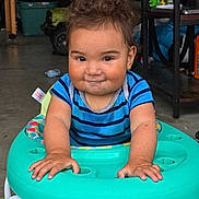 Michael joined the competition — help win amazing prizes! toddler, child, walker, blue_shirt, striped_shirt, indoor, smiling, messy_hair, hands, face, playtime, toy, garage, floor, furniture, person, cute, expression, young_child, casual