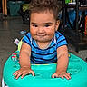 toddler, child, walker, blue_shirt, striped_shirt, indoor, smiling, messy_hair, hands, face, playtime, toy, garage, floor, furniture, person, cute, expression, young_child, casual