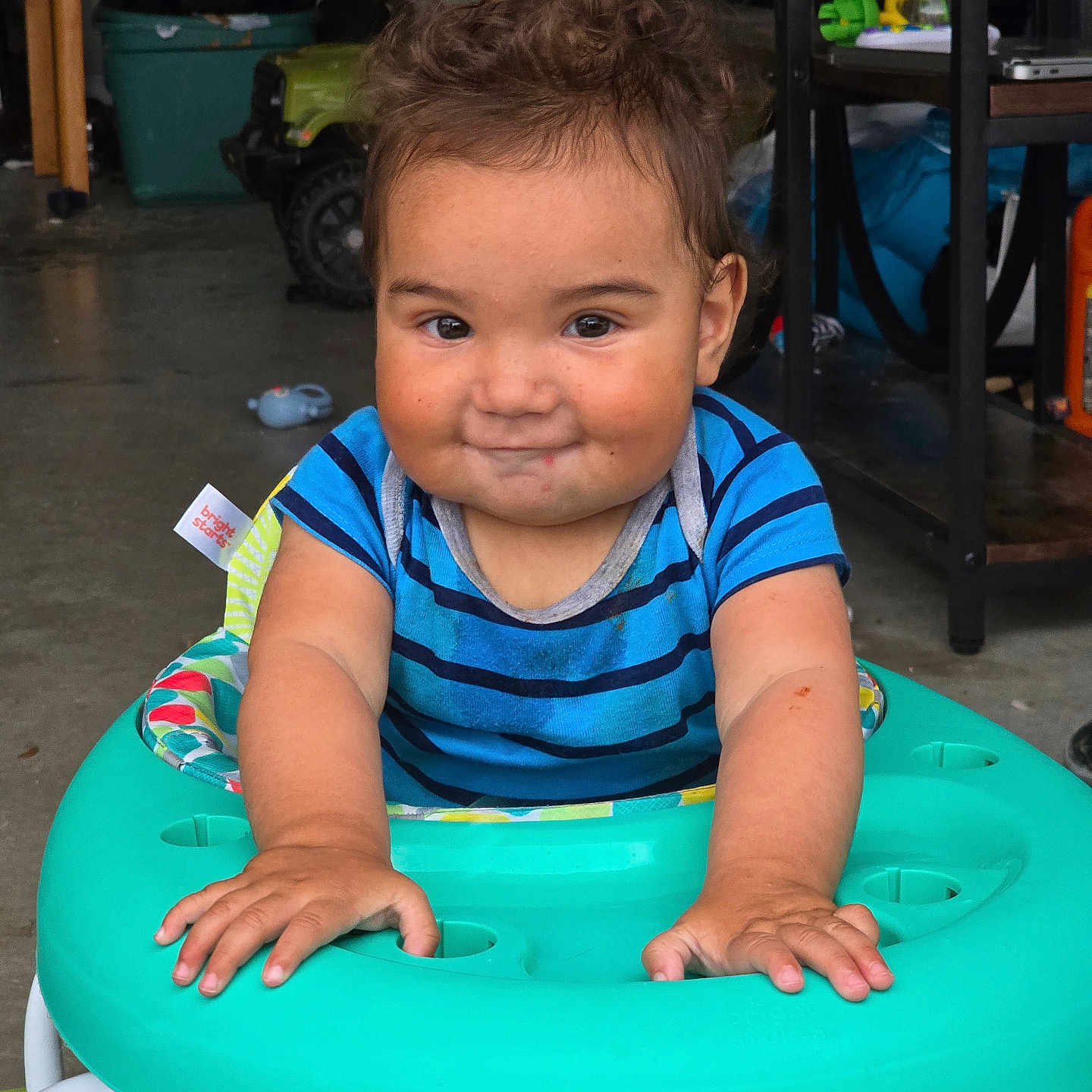 Michael joined the competition — help win amazing prizes! toddler, child, walker, blue_shirt, striped_shirt, indoor, smiling, messy_hair, hands, face, playtime, toy, garage, floor, furniture, person, cute, expression, young_child, casual
