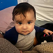 Ian is registered to the contest to win money with this photo: toddler, child, face, eyes, hair, blanket, clothing, indoor, portrait, curious, baby, expression, soft, warm, couch, person, sitting, hand, head, young