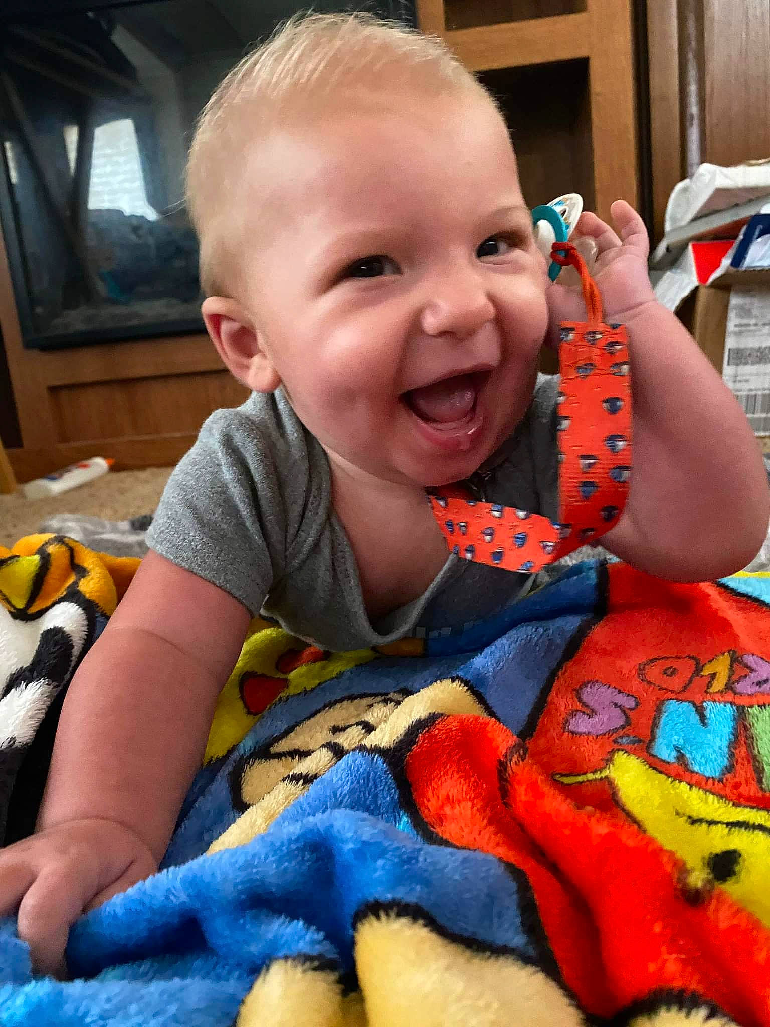 Cayson is registered to the contest to win money with this photo: arm, baby, baby_toddler_clothing, cheek, face, facial_expression, finger, happy, head, iris, lip, mouth, nose, orange, organ, person, product, skin, sleeve, smile