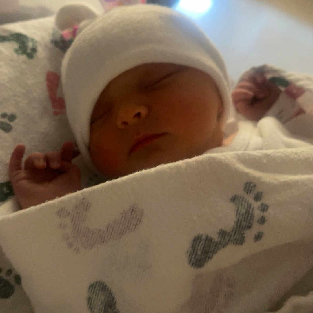 Kacie joined the competition — help win amazing prizes! newborn, baby, sleeping, blanket, hat, infant, cozy, footprints, soft, cute, peaceful, indoors, wrapped, child, portrait, resting, warm_light, closeup, face, adorable