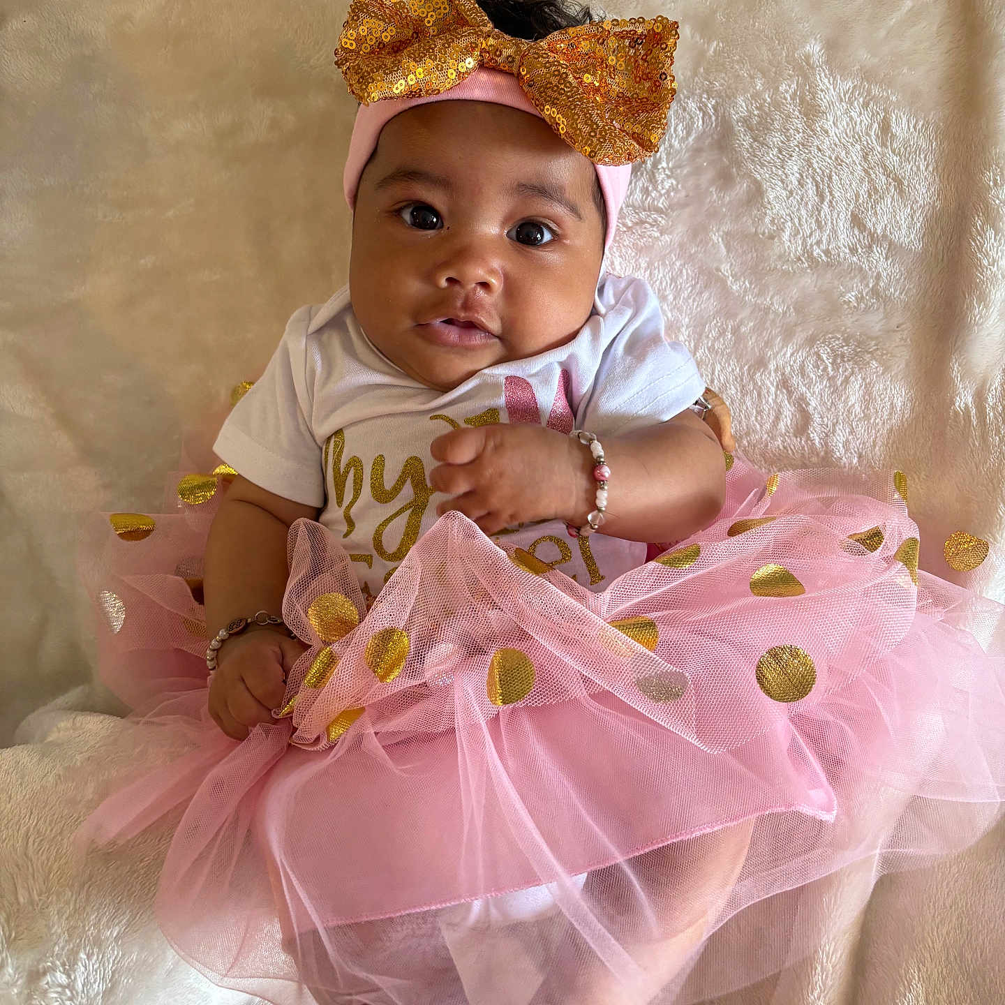 Dutchess joined the competition — help win amazing prizes! baby, bow, bracelet, child, clothing, cute, face, feet, gold, hands, happy, headband, indoors, infant, pink, portrait, sitting, soft_texture, tutu, white_blanket