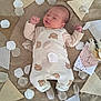 baby, infant, sleeping, overalls, bear_pattern, blanket, fabric_triangles, petals, milestone_card, bouquet, cozy, cute, soft_lighting, hands_up, lying_down, newborn, portrait, indoor, child, peaceful
