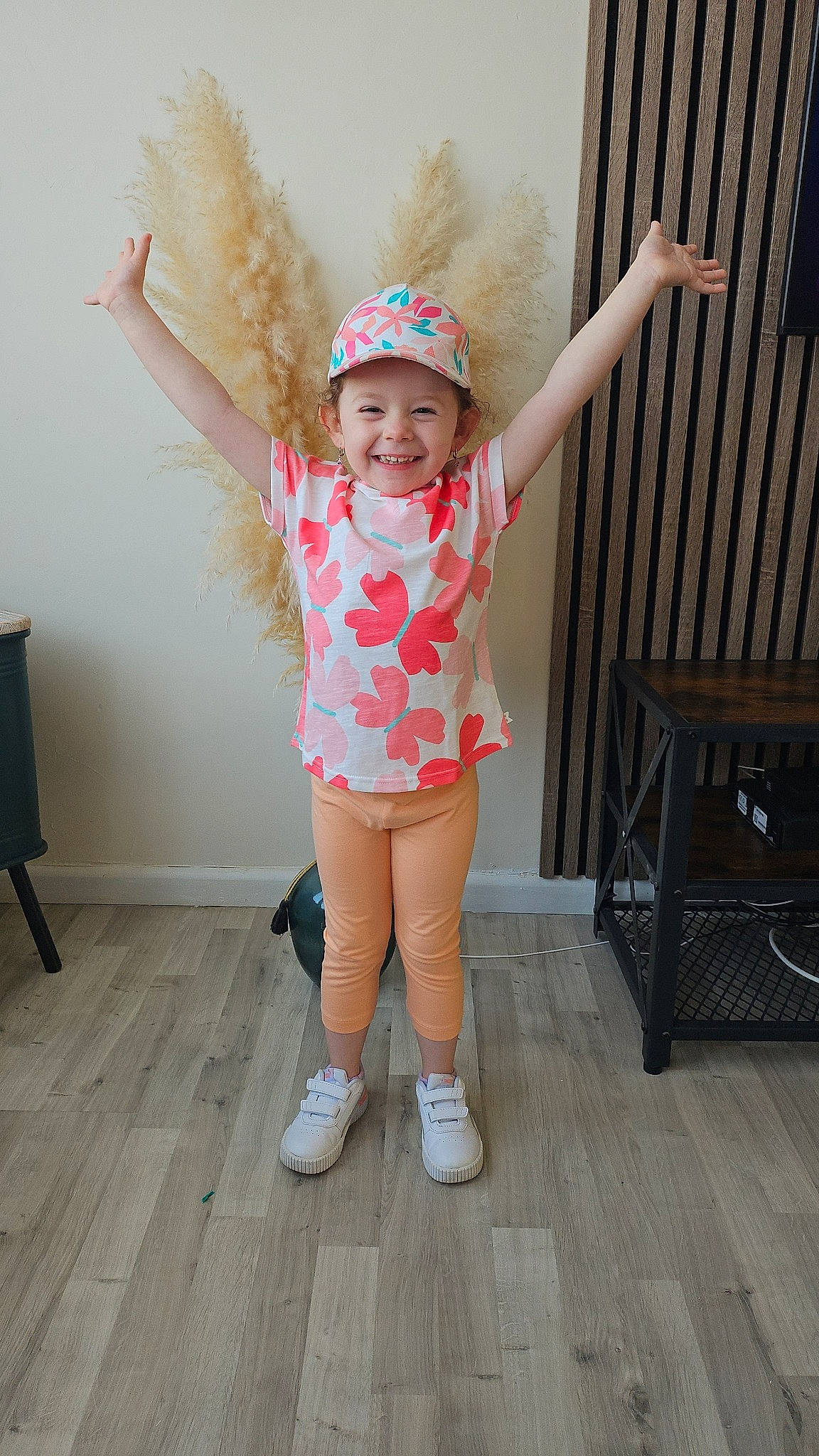 Lya a rejoint le concours — aidez-le/la à gagner de superbes lots ! baby_toddler_clothing, child, clothing, face, fashion_accessory, flooring, fun, gesture, happy, hardwood, headgear, headwear, human_leg, joy, knee, leg, pattern, person, pink, sleeve