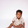 toddler, child, sitting, striped_shirt, curly_hair, white_background, studio, portrait, barefoot, casual_clothing, young_child, expression, face, person, indoor, isolated, fashion, cute, one_person, baby