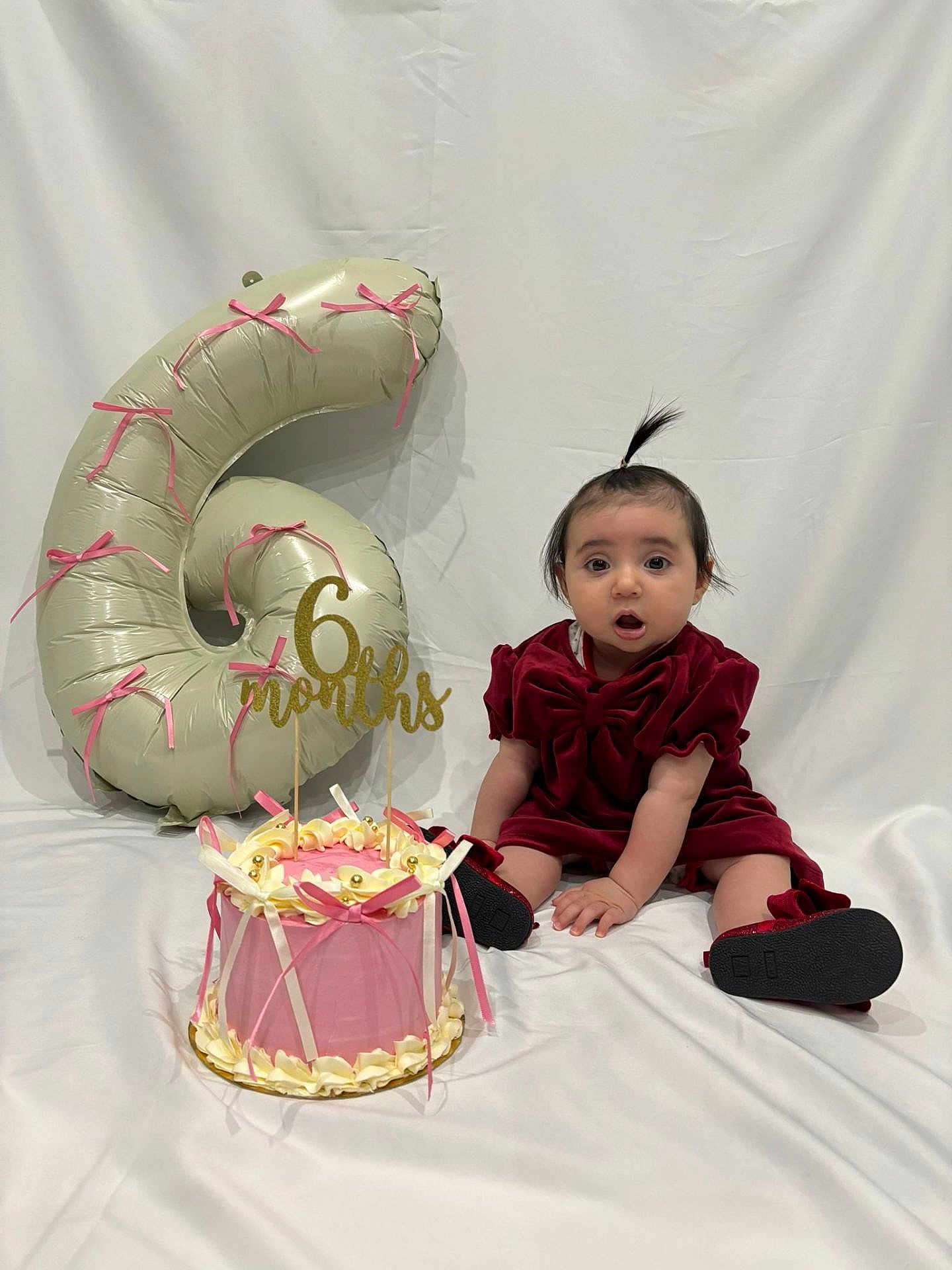 Elisa a rejoint le concours — aidez-le/la à gagner de superbes lots ! baby, infant, child, cake, balloon, number_6, celebration, milestone, red_dress, sitting, white_background, ribbons, decorations, portrait, cute, birthday, party, smiling, indoors, photography