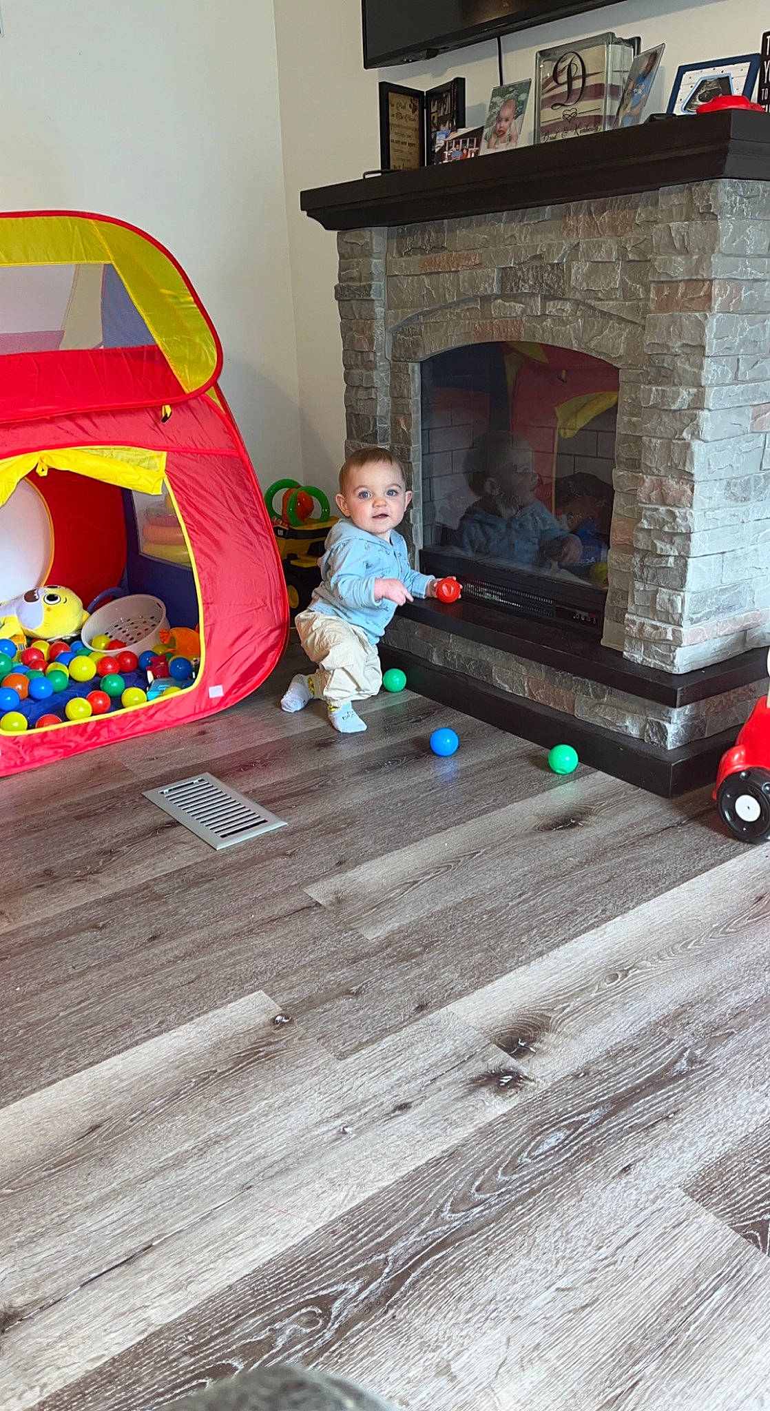 Hudson is registered to the contest to win money with this photo: baby, baby_toddler_clothing, baby_toys, child, comfort, fireplace, flooring, fun, gas, hardwood, hearth, house, leisure, person, play, room, sitting, toddler, toy, tree