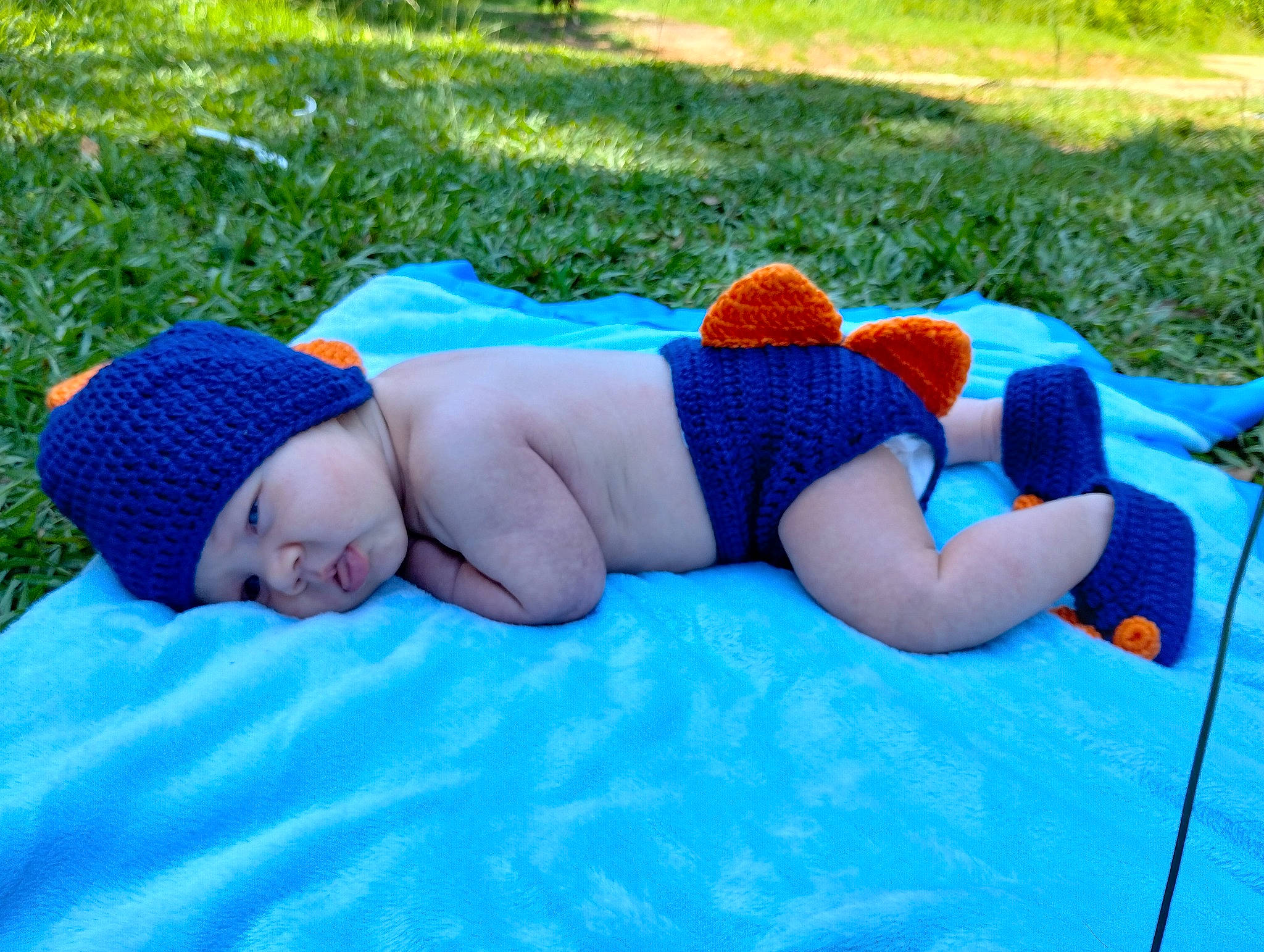 Lane is registered to the contest to win money with this photo: abdomen, azure, baby, barechested, barefoot, cap, electric_blue, fun, grass, grassland, headwear, hood, human_leg, lawn, leisure, people_in_nature, person, plant, recreation, sun_hat