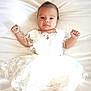 Robyne participe au concours pour gagner de l'argent avec cette photo : baby, infant, white_dress, lace, portrait, lying_down, cute, child, smile, hands_up, soft_light, indoors, necklace, skin, head, eyes, young_child, bed, fabric, adorable