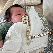 Layan a rejoint le concours — aidez-le/la à gagner de superbes lots ! baby, pacifier, blanket, beads, cushion, infant, person, face, sleeping, indoors, fabric, clothing, bedroom, comfort, cute, resting, toddler, child, home, soft