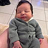 Layan a rejoint le concours — aidez-le/la à gagner de superbes lots ! baby, infant, sleeping, knitwear, gray_clothing, hand, footwear, tile_floor, indoor, person, resting, cute, soft_lighting, cozy, newborn, casual, relaxed, human, seated, portrait