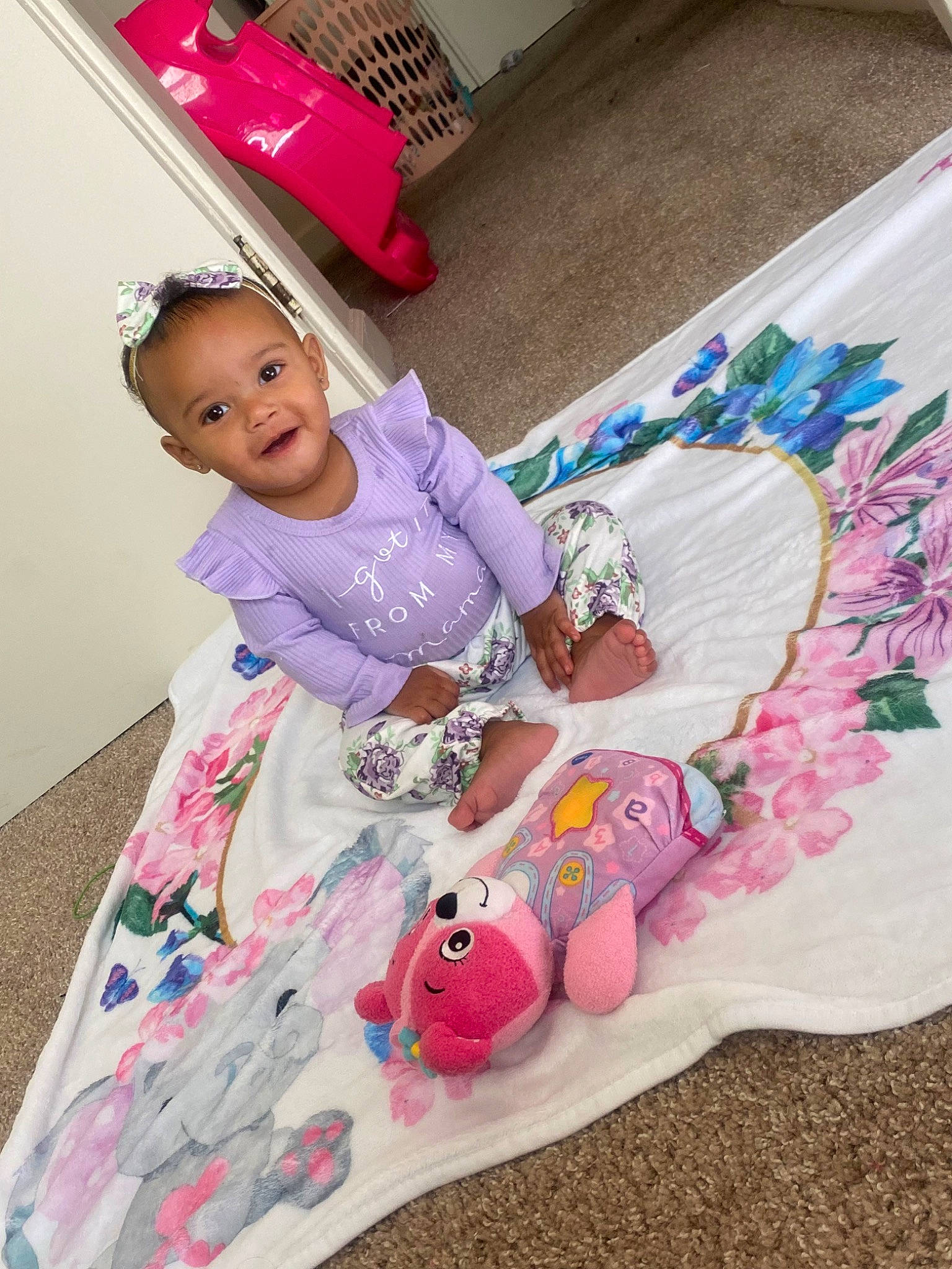 Kayla is registered to the contest to win money with this photo: baby, baby_products, baby_toddler_clothing, child, dress, face, flooring, fun, happy, head, joy, linens, magenta, pattern, person, pink, purple, sitting, skin, sleeve