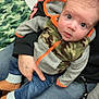 Colten joined the competition — help win amazing prizes! baby, boots, camouflage, casual, child, curious, denim, eyes, face, footwear, hand, hoodie, indoor, jacket, jeans, lap, orange, person, sitting, tattoo
