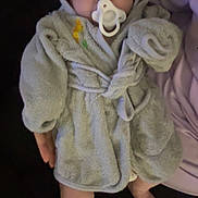 Colten is registered to the contest to win money with this photo: baby, blanket, child, comfort, cozy, cute, foot, hand, hooded_clothing, indoors, infant, lying_down, pacifier, person, robe, skin, sleepwear, soft_texture, toddler, young_child