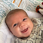 Colten is registered to the contest to win money with this photo: baby, baby_seat, bear_pattern, blanket, carpet, child, clothing, cozy, cushion, cute, cute_baby, face, happy, indoors, infant, person, portrait, resting, smiling, socks