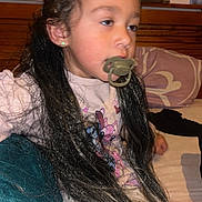 Eléyana participe au concours pour gagner de l'argent avec cette photo : child, pacifier, long_hair, bed, pillow, blanket, indoor, sleepy, clothing, earrings, wooden_headboard, person, portrait, young_child, fabric, home, casual, relaxed, sleepwear, cozy