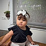 baby, child, headband, bow, black_top, white_leggings, smiling_patch, white_shoes, table, indoor, window, plant, hand, cute, portrait, sitting, face, young_child, clothing, home