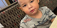 Ezra joined the competition — help win amazing prizes! toddler, child, boy, dinosaur_shirt, restaurant, booth, table, patterned_fabric, indoor, casual, curious, messy_face, young_child, beard, glass_window, seated, people, clothing, candid, portrait