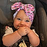 baby, infant, car_seat, headband, pink, keys, chewing, cute, child, closeup, face, smile, happy, straps, seatbelt, young_child, indoor, person, adorable, portrait