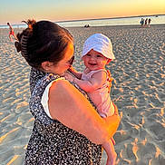 Malia a rejoint le concours — aidez-le/la à gagner de superbes lots ! baby, beach, family, happy, hat, holding, nature, ocean, outdoor, person, sand, sky, smile, summer, sunlight, sunset, vacation, warm_light, water, woman