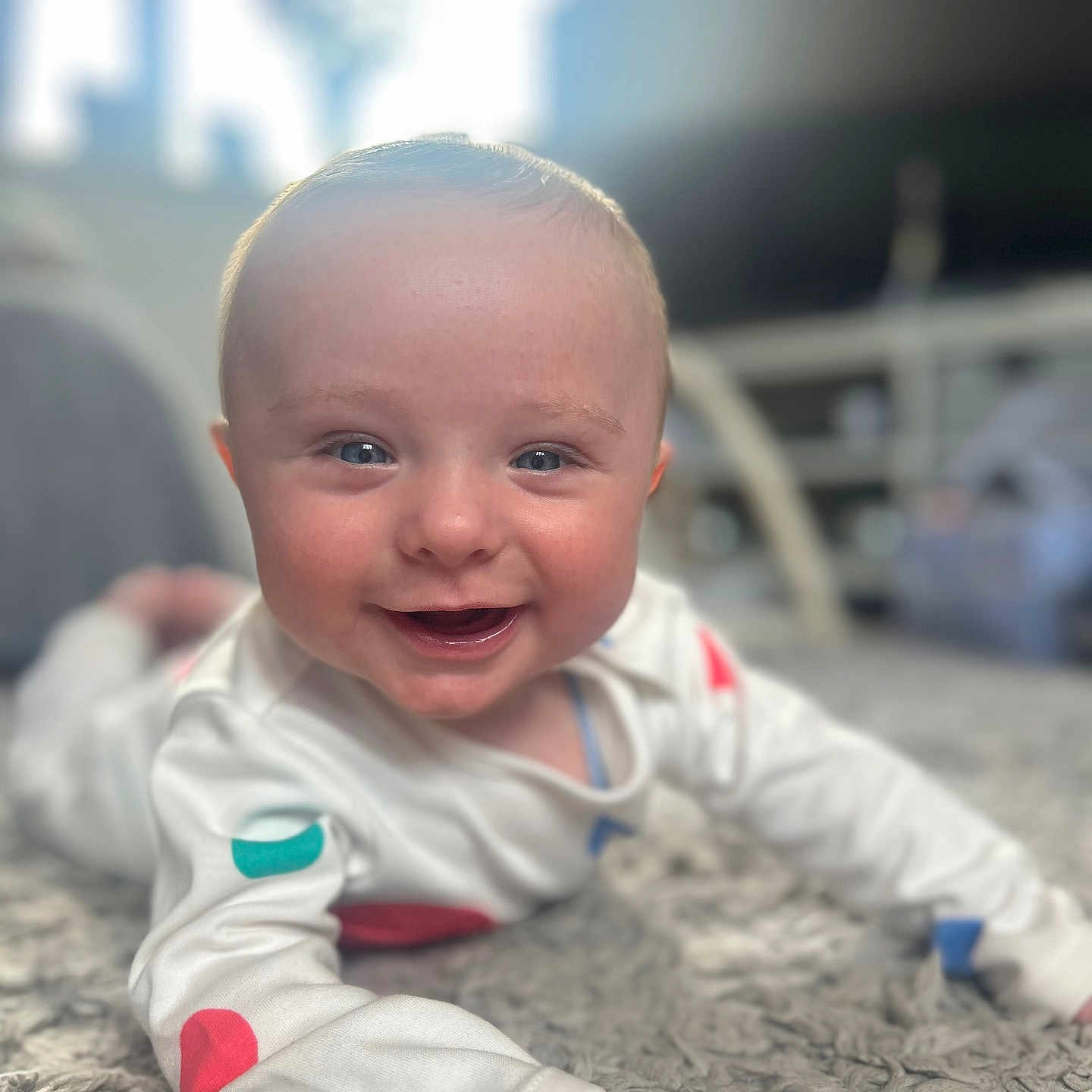Harry joined the competition — help win amazing prizes! baby, carpet, child, closeup, colorful_spots, cute, eyes, face, happy, home, indoor, infant, lying_down, person, portrait, skin, smiling, soft_light, white_clothing, young