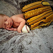 Ander is registered to the contest to win money with this photo: baby, ball, baseball, baseballball, baseballglove, blanket, bodypart, clothing, face, finger, glove, hat, head, newborn, people, person, photography, portrait, sleeping, sport