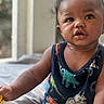 Thomas is registered to the contest to win money with this photo: baby, child, toddler, curly_hair, tank_top, dinosaur_print, indoor, natural_light, toy, playing, closeup, person, cute, expression, skin, face, hand, sitting, window, soft_surface