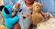 Thomas joined the competition — help win amazing prizes! baby, smiling, blue_blanket, plush_toy, teddy_bear, blue_plush_dog, bottle, onesie, happy, infant, child, blanket, soft_toy, cute, lying_down, cheerful, indoors, face, person, cozy