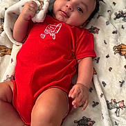 Samuel joined the competition — help win amazing prizes! baby, infant, child, onesie, red_clothing, blanket, lying_down, portrait, close_up, adorable, hand, face, eyes, hair, bedding, soft_texture, cozy, nursery, skin, smile