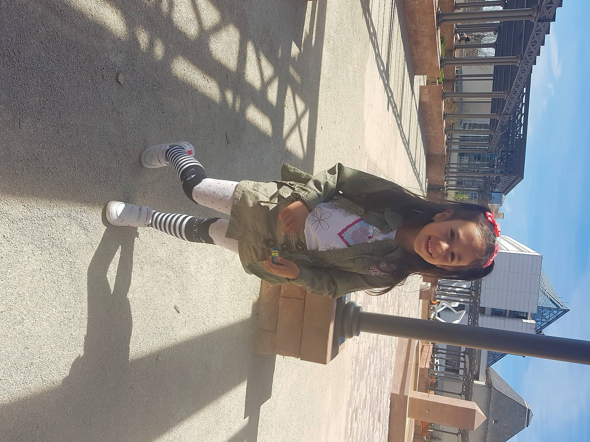 Aryanna participe au concours pour gagner de l'argent avec cette photo : building, city, composite_material, concrete, facade, fun, joy, leisure, pedestrian, person, road_surface, shadow, sky, smile, street_fashion, travel