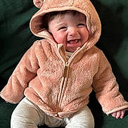 Edie joined the competition — help win amazing prizes! baby, child, clothing, cozy, cute, face, happy, hoodie, indoor, infant, jacket, pants, person, pink, portrait, sitting, smiling, soft_texture, teddy_bear_ears, warm