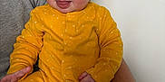 Edie joined the competition — help win amazing prizes! adult_arm, baby, blue_eyes, child, clothing, cute, expression, face, hair, happy, holding, indoor, infant, person, playful, sitting, skin, smiling, tongue_out, yellow_onesie