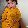 baby, infant, child, yellow_onesie, tongue_out, cute, playful, person, indoor, sitting, smiling, hair, blue_eyes, adult_arm, holding, clothing, face, skin, expression, happy
