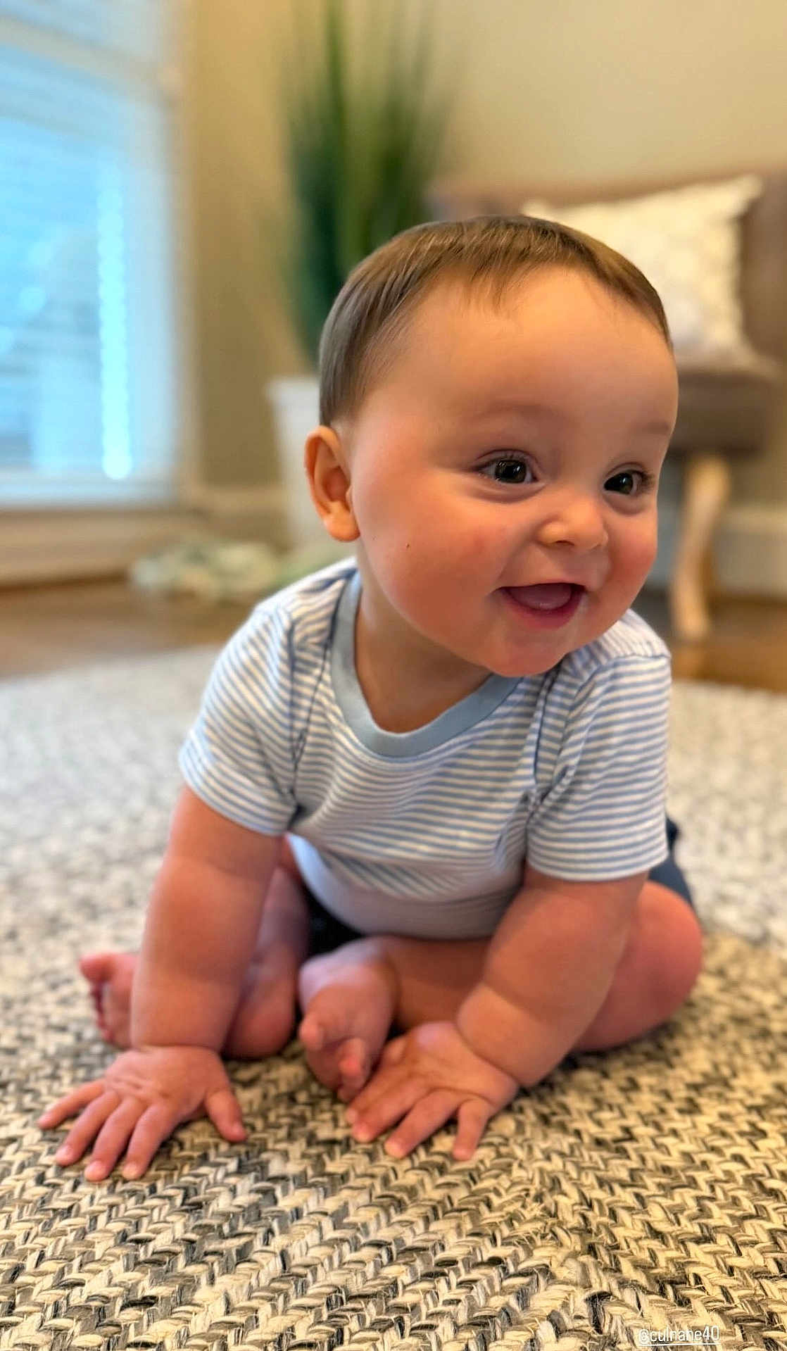 Cohen is registered to the contest to win money with this photo: baby, child, crawling, smiling, happy, indoor, rug, carpet, striped_shirt, cute, infant, chubby_cheeks, hands, feet, floor, home, blurred_background, light, portrait, person