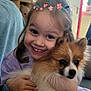 child, dog, pomeranian, hug, smile, indoor, cute, pet, fluffy, happy, face, purple_clothing, hair, hand, toy, window, plant, furniture, heart, filter