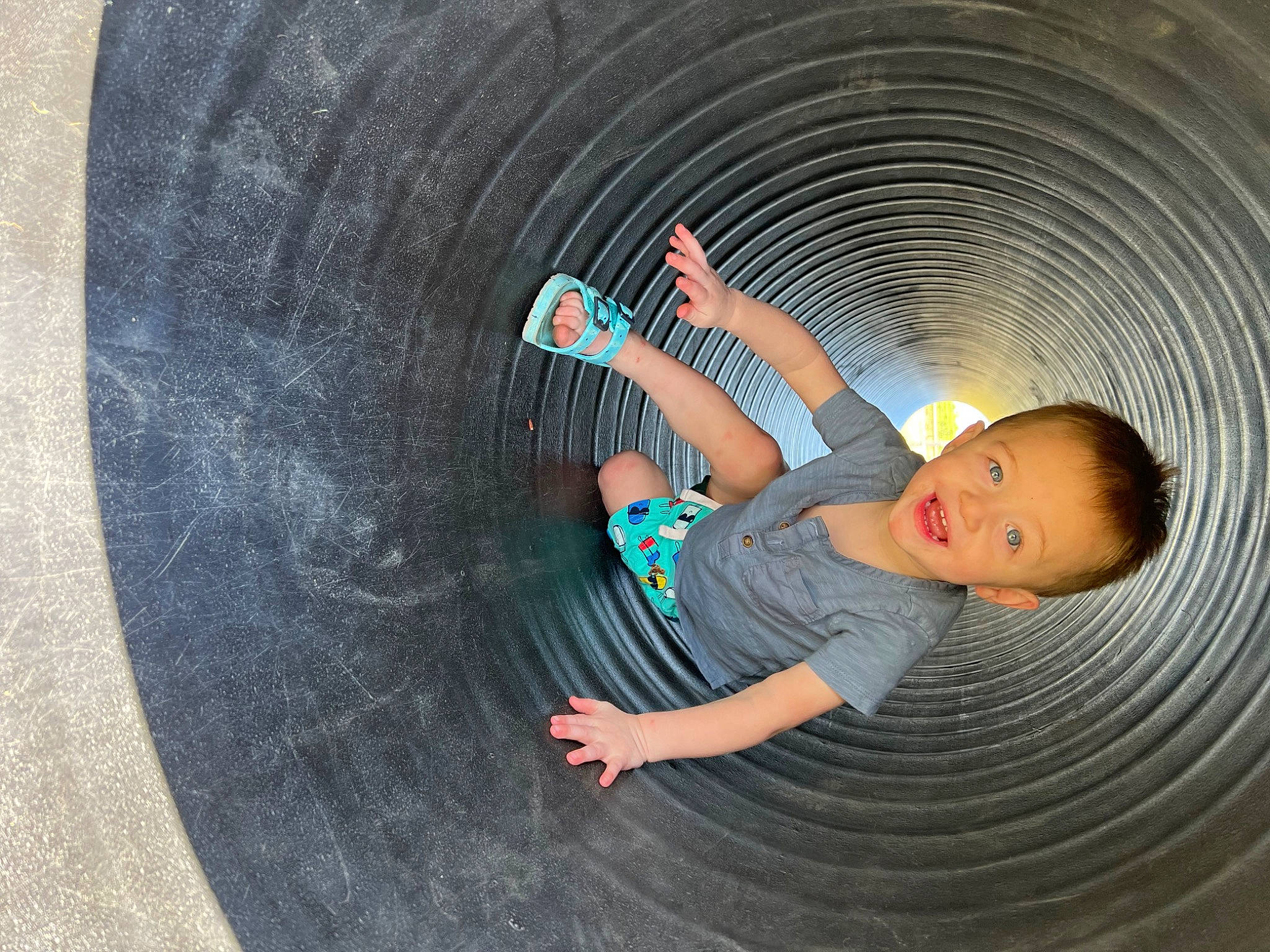 Azaiah is registered to the contest to win money with this photo: automotive_tire, automotive_wheel_system, child, circle, comfort, concrete, darkness, flash_photography, flooring, fun, grass, leisure, pattern, person, play, recreation, sitting, t_shirt, toddler, tree