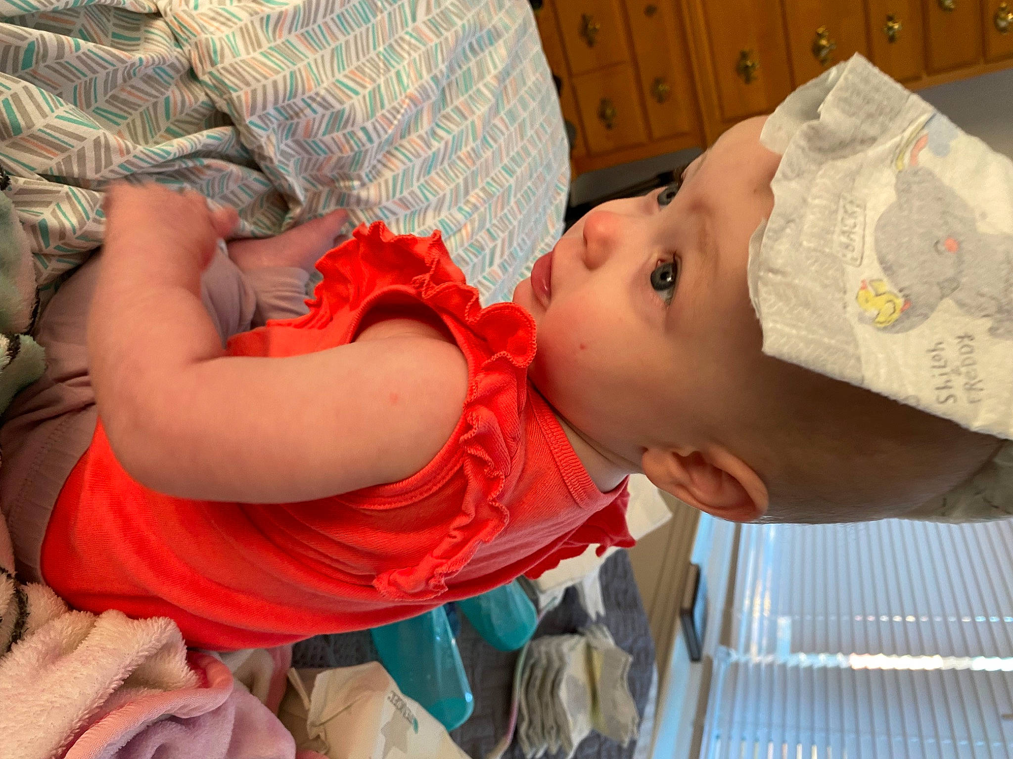 Stella is registered to the contest to win money with this photo: abdomen, arm, baby, baby_products, baby_toddler_clothing, cheek, child, comfort, elbow, fun, happy, headgear, headwear, human_leg, mouth, pattern, person, room, skin, sleeve