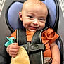 Lynnix is registered to the contest to win money with this photo: baby, car_seat, infant, smile, dimple, pacifier, blanket, safety_harness, orange_shirt, child, cute, happy, indoor, closeup, person, seat, head, hand, comfort, portrait