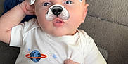 Cavan is registered to the contest to win money with this photo: baby, blue_cloth, carpet, casual, child, cute, dog_ears, dog_nose, face_filter, filter, hand, indoor, infant, lying_down, onesie, patterned_fabric, planets, playful, portrait, space_theme