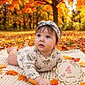baby, infant, child, autumn, fall, forest, outdoors, leaves, orange, portrait, lying_down, blanket, headband, floral_clothing, milestone_photo, four_months, baby_card, natural_light, smiling, family_photography