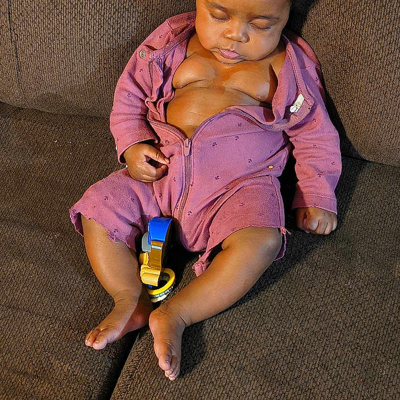 Empress joined the competition — help win amazing prizes! baby, child, sleeping, couch, furniture, indoors, onesie, toy, relaxing, infant, peaceful, cozy, purple_clothing, hair, legs, feet, hand, face, resting, living_room