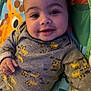 baby, smiling, infant, face, clothing, grey_outfit, yellow_cheetah_prints, hand, play_mat, giraffe, colorful, lying_down, cute, child, indoors, portrait, young, happy, person, soft_lighting