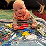 Scarlette is registered to the contest to win money with this photo: baby, infant, water_mat, colorful, play, dog, pet, blanket, indoor, cute, smiling, child, floor, hand, face, animal, toy, bright, person, happy